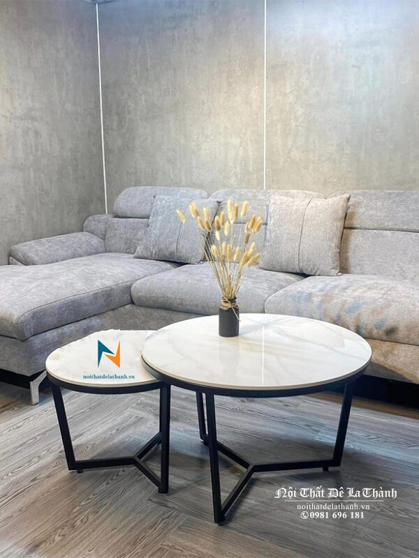 Bộ sofa góc bọc nhung màu ghi sáng phù hợp đi cùng với chiếc bàn trà mặt đá màu sáng, tạo nên sự đồng tone đẹp mắt