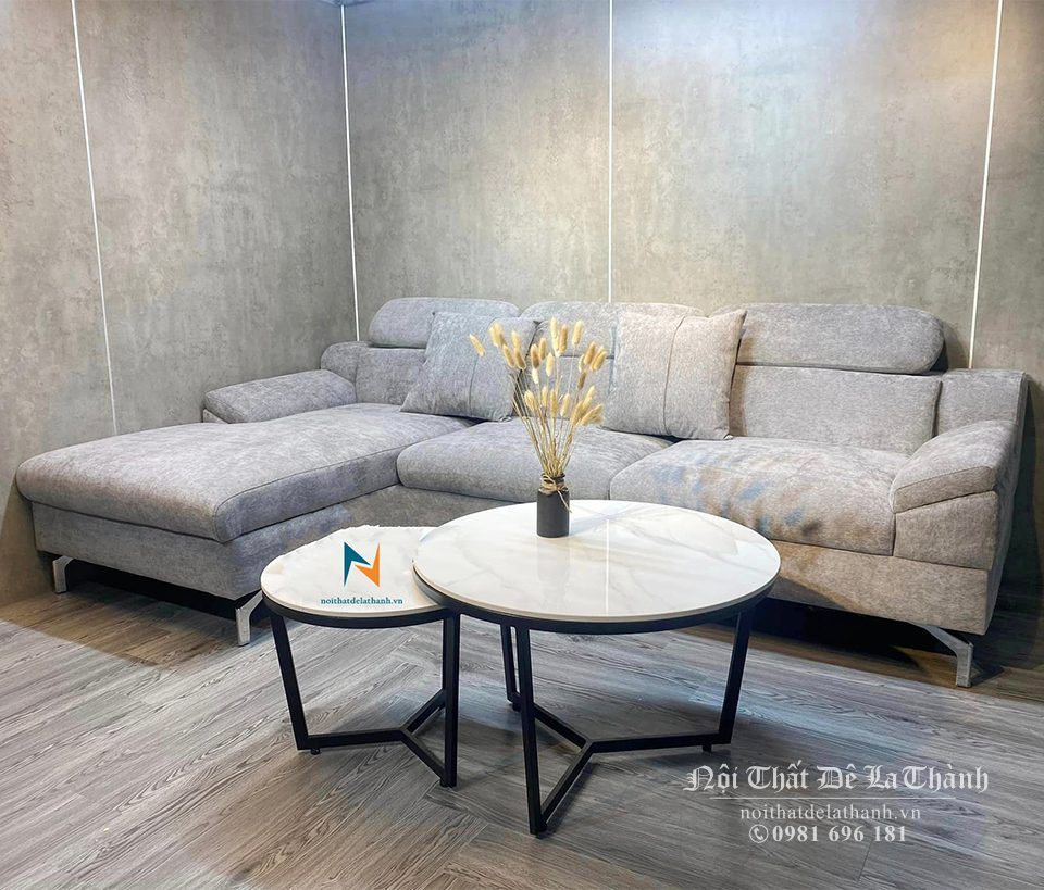Bộ sofa góc bọc nhung màu ghi sáng phù hợp đi cùng với chiếc bàn trà mặt đá màu sáng, tạo nên sự đồng tone đẹp mắt