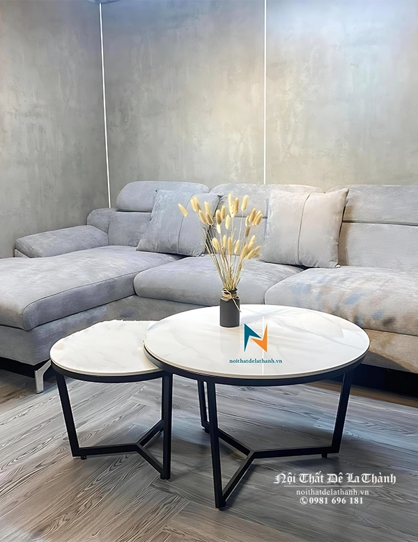 Bộ sofa góc bọc nhung màu ghi sáng phù hợp đi cùng với chiếc bàn trà mặt đá màu sáng, tạo nên sự đồng tone đẹp mắt