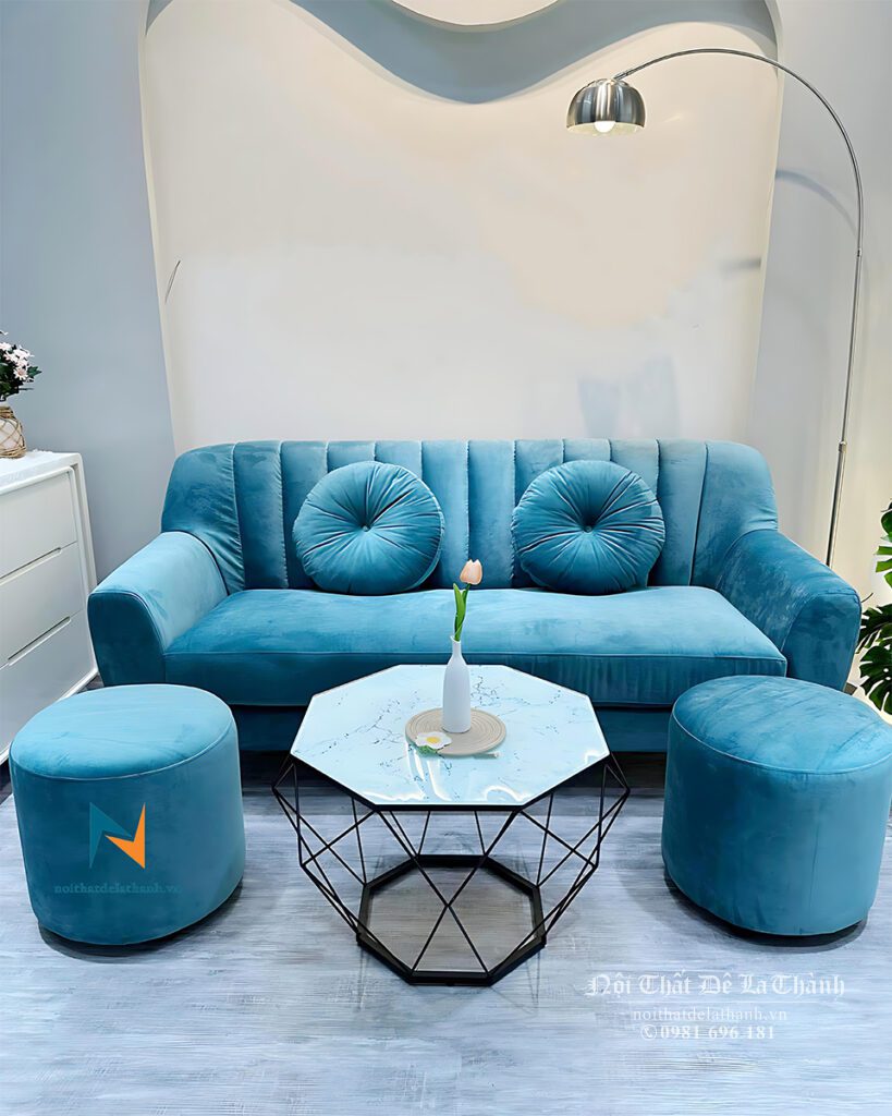 Chiếc sofa văng bọc nhung màu xanh, có thiết kế đặc trưng với tựa may kiểu chia sọc, 2 chỗ ngồi