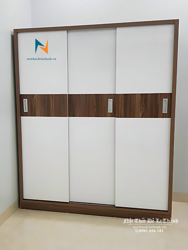 Chiếc tủ áo 3 cánh lùa 1m8x2m, phối màu óc chó và màu cánh trắng, có 1 vệt màu nâu óc chó chạy ngang giữa 3 cánh rất đẹp