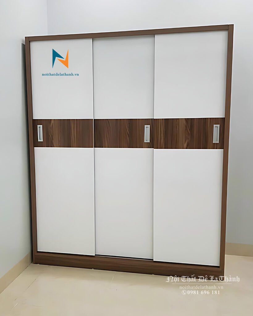 Chiếc tủ áo 3 cánh lùa 1m8x2m, phối màu óc chó và màu cánh trắng, có 1 vệt màu nâu óc chó chạy ngang giữa 3 cánh rất đẹp