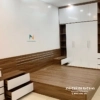 Chiếc tủ được thiết kế theo phong cách hiện đại, thanh thoát với 2 kệ góc 2 bên, kích thước 2m4x2m6 full trần, phối màu gỗ nâu tối và màu cánh trắng tương phản