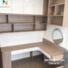 Phía đối diện giường là bàn làm việc chữ L: một vế 60cm kiêm bàn phấn, vế còn lại 1m, bên trên là giá sách