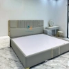 Chiếc giường cưới bọc da màu xanh toàn thân, chất liệu gỗ công nghiệp mdf, kích thước 1m8x2m, đầu cao chia thành các mảnh nhỏ, đầu thấp ở chính giữa chia các mảnh nhỏ giống thiết kế đầu cao, có 4 thanh nẹp màu vàng ở đầu cao và đầu thấp làm điểm nhấn cho chiếc giường trở lên sang trọng