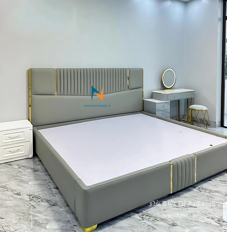 Chiếc giường cưới bọc da màu xanh toàn thân, chất liệu gỗ công nghiệp mdf, kích thước 1m8x2m, đầu cao chia thành các mảnh nhỏ, đầu thấp ở chính giữa chia các mảnh nhỏ giống thiết kế đầu cao, có 4 thanh nẹp màu vàng ở đầu cao và đầu thấp làm điểm nhấn cho chiếc giường trở lên sang trọng