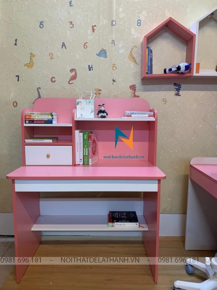 Bàn học bé gái lớp 1 chất liệu gỗ MDF thiết kế theo phong cách hiện đại, bàn học liền giá sách thấp để bé dễ sử dụng, gồm 2 màu cơ bản là màu hồng pha trắng