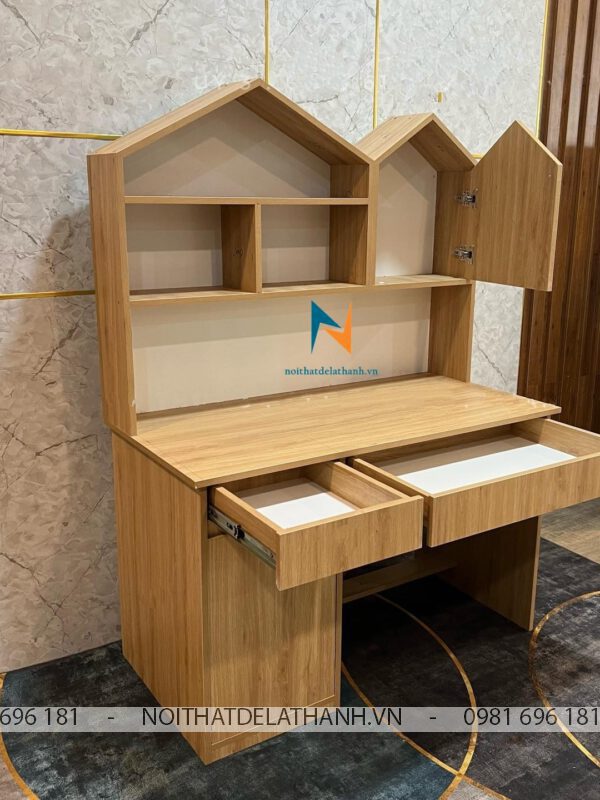 Chiếc bàn học cho học sinh tiểu học có thiết kế giá sách liền bàn học, giá sách thấp để bé dễ lấy đồ, có 1 cánh mở, 2 ngăn kéo, giá sách hình mái nhà được các bé rất yêu thích