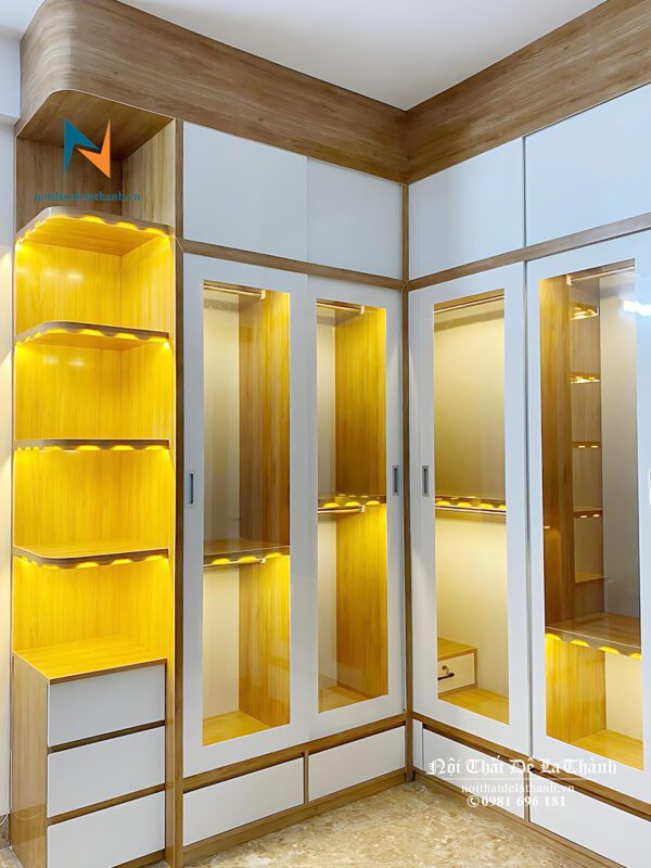 Chiếc tủ quần áo công nghiệp cánh kính thiết kế theo phong cách hiện đại rất đẹp mắt, tủ góc chữ L, bên trái là góc trang trí, các khoang được lắp đèn led đẹp mắt