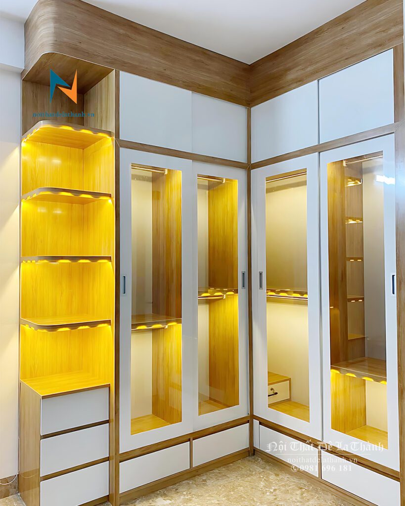 Chiếc tủ quần áo công nghiệp cánh kính thiết kế theo phong cách hiện đại, tủ góc chữ L, bên trái là góc trang trí, các khoang được lắp đèn led đẹp mắt