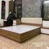 Chiếc giường hiện đại đầu bọc nỉ, đi kèm với táp và bàn trang điểm chân đứng trong combo nội thất phòng ngủ hiện đại