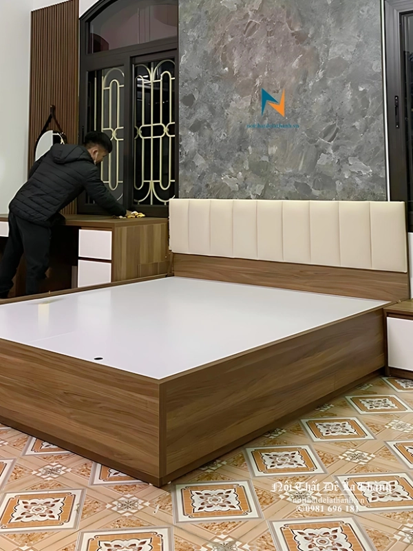 Chiếc giường hiện đại đầu bọc nỉ, đi kèm với táp và bàn trang điểm chân đứng trong combo nội thất phòng ngủ hiện đại