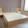 Chiếc giường trong combo giá rẻ, đầu giường bọc nệm, 2 bên là 2 táp treo, vách ốp gỗ