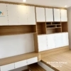 Phía đuôi giường là hệ thống các ngăn tủ mở, bên cạnh là chiếc bàn học 1m, giá sách cao kịch trần