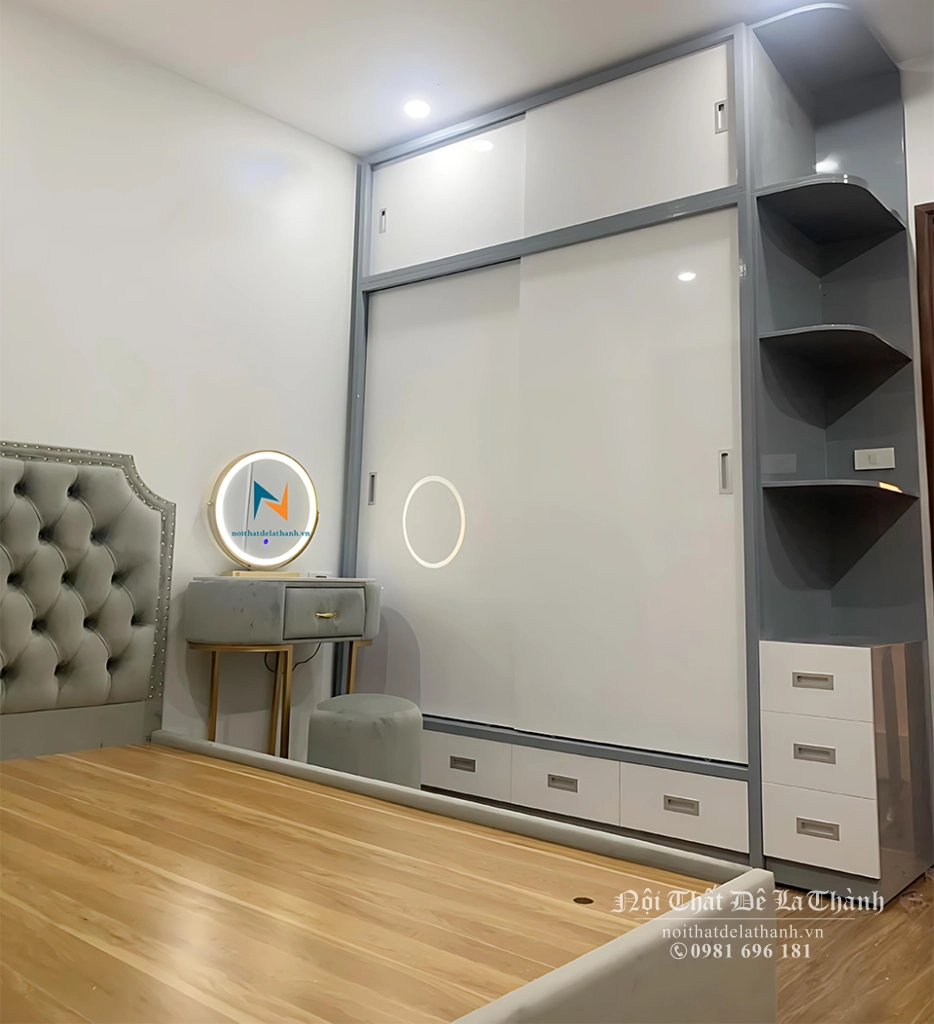 Phòng ngủ màu xám trắng thiết kế theo phong cách decor, phù hợp dành cho nữ hay làm phòng cưới, với chiếc giường 1m6 bọc nệm (nhung) toàn thân, tủ cánh lùa 2mx2m6, bàn phấn decor bọc nhung đi kèm gương led tròn và đôn tròn rất đẹp mắt