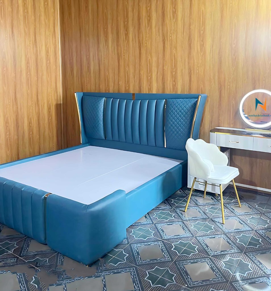 Hình ảnh thực tế chiếc giường cao cấp bọc da màu xanh toàn thân, thiết kế đầu cao và đầu thấp chia mảnh xen kẽ là các nẹp màu vàng sang trọng