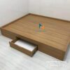 Chiếc giường bệt không đầu cao có ngăn kéo, kích thước 1m6x2m, màu nâu vân gỗ, vai trái có 1 ngăn kéo để đồ