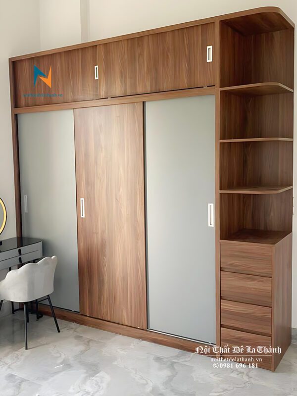 Chiếc tủ gỗ công nghiệp mdf 3 cửa lùa có kích thước 2mx2m45, thiết kế 2 tầng, bên phải có kệ góc trang trí, phối 2 màu óc chó và màu chì rất đẹp