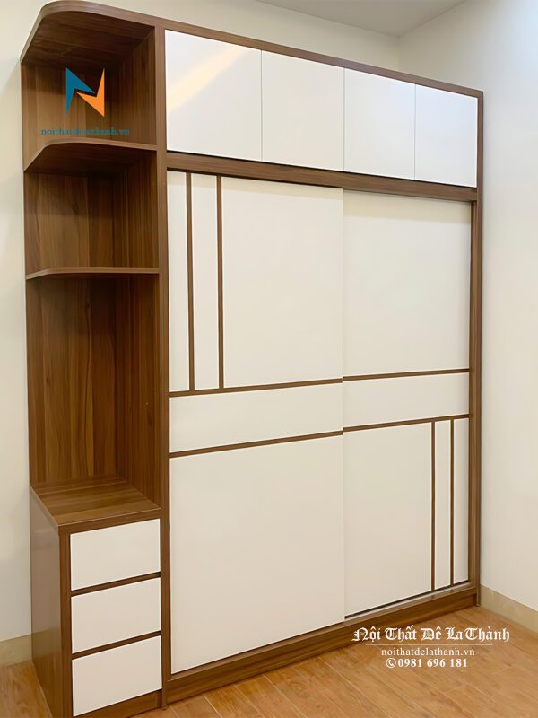 Chiếc tủ hiện đại 2 cánh lùa, gỗ mdf, kích thước 2mx2m45, thiết kế 2 tầng, bên trái có kệ trang trí, cánh được dán các đường chỉ decor rất đẹp
