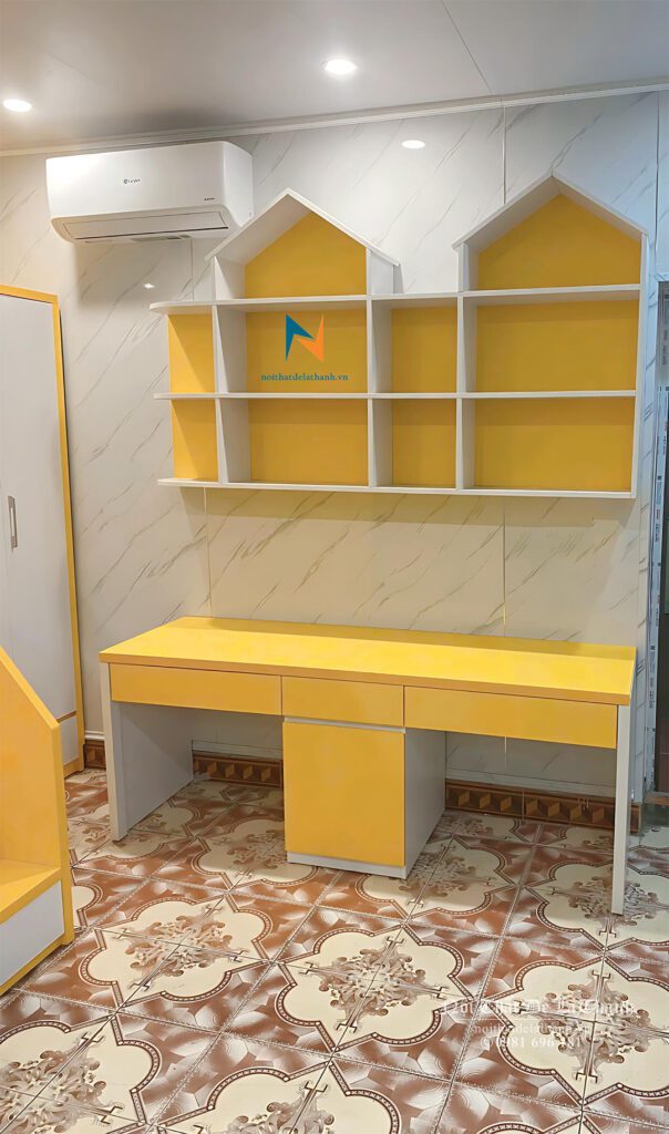 Chiếc bàn học đôi kèm giá sách cho 2 bé trai, màu vàng pha màu trắng, kích thước bàn 1m8x75cm, giá sách 1m8x90cm, giữa bàn có hộc tủ để đồ tiện lợi
