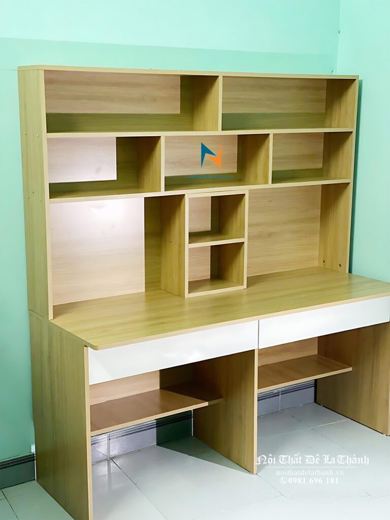 Chiếc bàn dành cho 2 bé trai cấp 1, kích thước 1m6x1m95, gỗ mdf, phối màu gỗ vàng nâu, mặt cánh ngăn kéo màu trắng, thiết kế kiểu bàn học liền giá sách