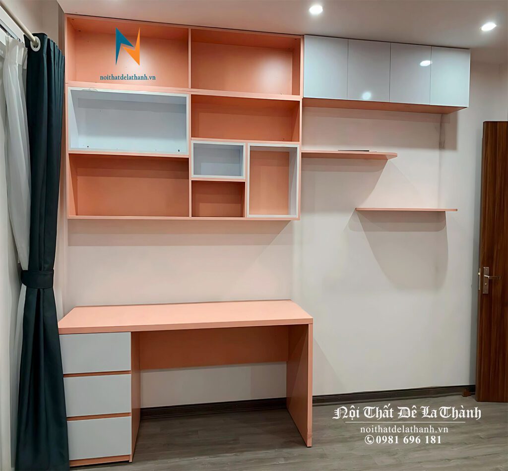 Chiếc bàn học màu hồng pha trắng, rộng 1m kèm giá sách treo cao kịch trần và phần giá sách thiết kế rộng thêm 1m nữa về bên phải, tối ưu không gian sử dụng cho bé gái