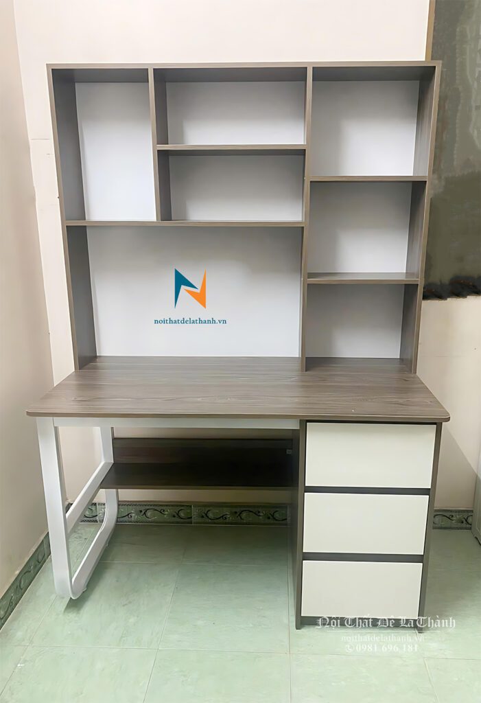 Chiếc bàn học phối màu nâu và màu trắng dành cho học sinh cấp 2, bên phải chỗ ngồi là tủ đồ, bên trái là chiếc chân chữ U bằng sắt sơn tĩnh điện, thiết kế bàn liền giá sách 1mx1m95