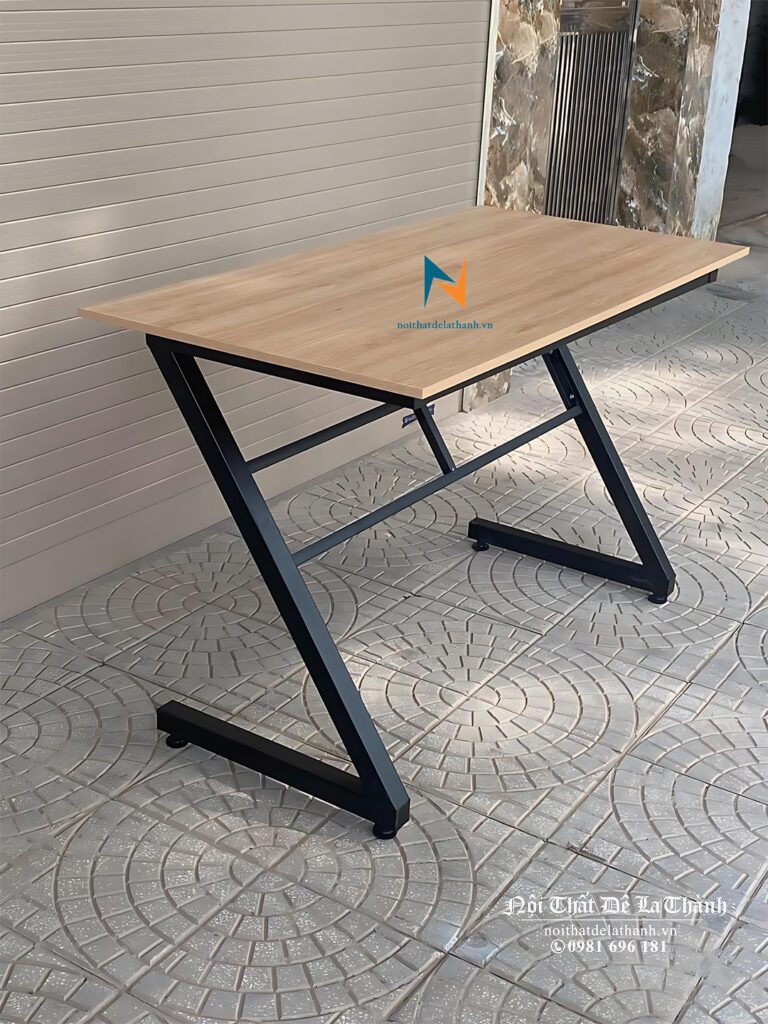 Chiếc bàn chân sắt chữ Z màu đen, màu bàn màu gỗ nâu, dài 1m2, bàn thuộc phân khúc giá rẻ, sử dụng như bàn học hoặc bàn làm việc