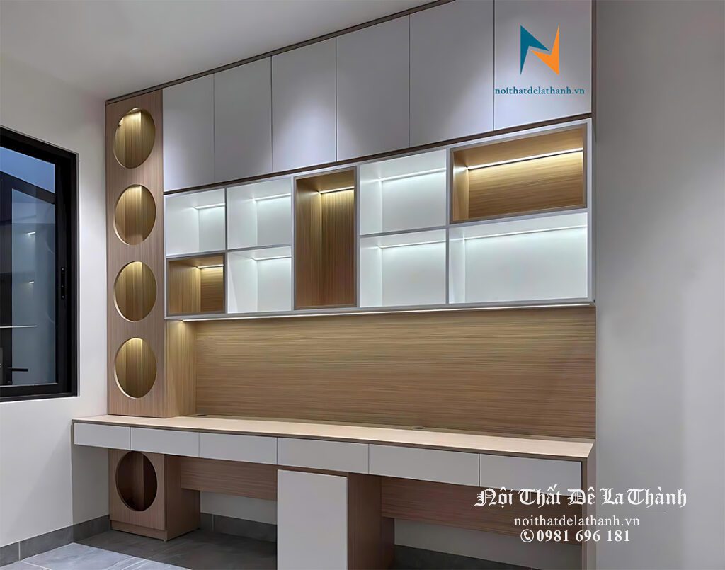 Chiếc bàn học 2m4x2m6 kịch trần thiết kế cho 2 bạn cấp 3, trong giá sách có đèn led, bên trái thiết kế hình cột với các ô tròn gây ấn tượng mạnh, sử dụng màu gỗ vàng nhạt, cánh màu trắng
