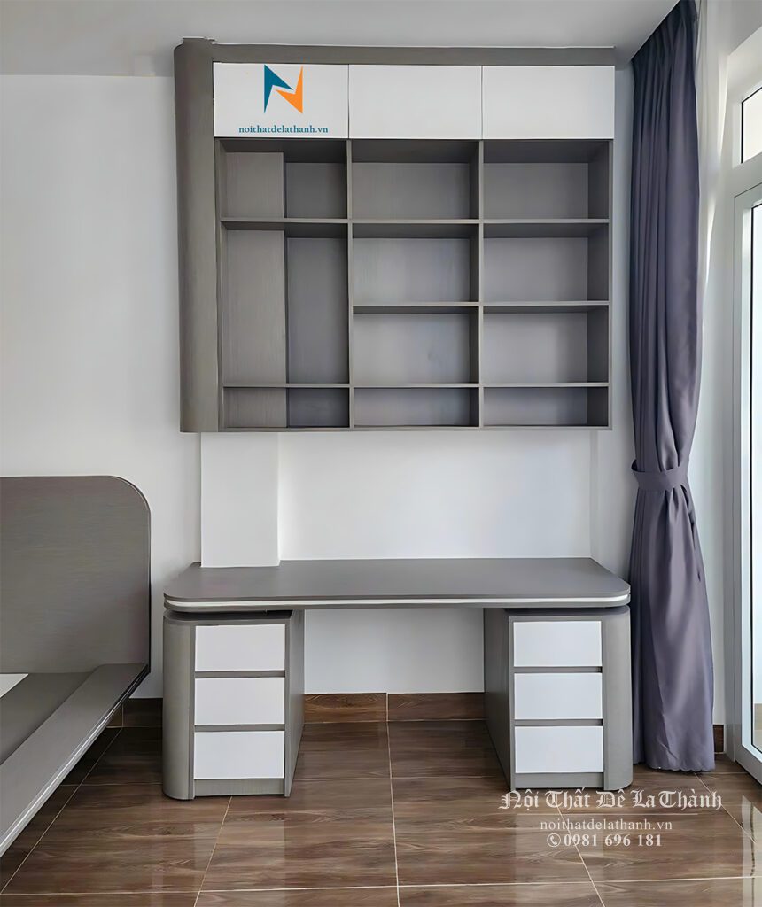 Chiếc bàn học thiết kế theo kiểu hiện đại có thể dùng cho cả sinh viên nam hoặc sinh viên nữ, phối màu chì nhạt và màu cánh trắng, bàn dài 1m6 với 2 tủ đồ 2 bên, bo cong, giá sách treo 1m6x1m4, phần trên cùng của giá có cánh, bên dưới để hở, thiết kế ôm cột gọn gàng