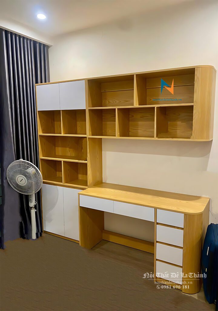 Chiếc bàn học rộng 1m, giá sách treo 1mx60cm, đứng cạnh là chiếc tủ sách 80cmx2m, toàn bộ là màu sồi tươi pha cánh màu trắng, thiết kế theo kiểu hiện đại, dành cho các học sinh phổ thông