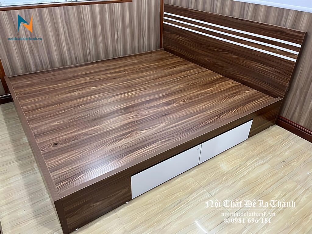 Chiếc giường ngủ Nội Thất Đê La Thành lắp đặt bằng gỗ công nghiệp 1m8x2m, màu óc chó, thiết kế theo phong cách hiện đại với 2 ngăn kéo ở vai giường